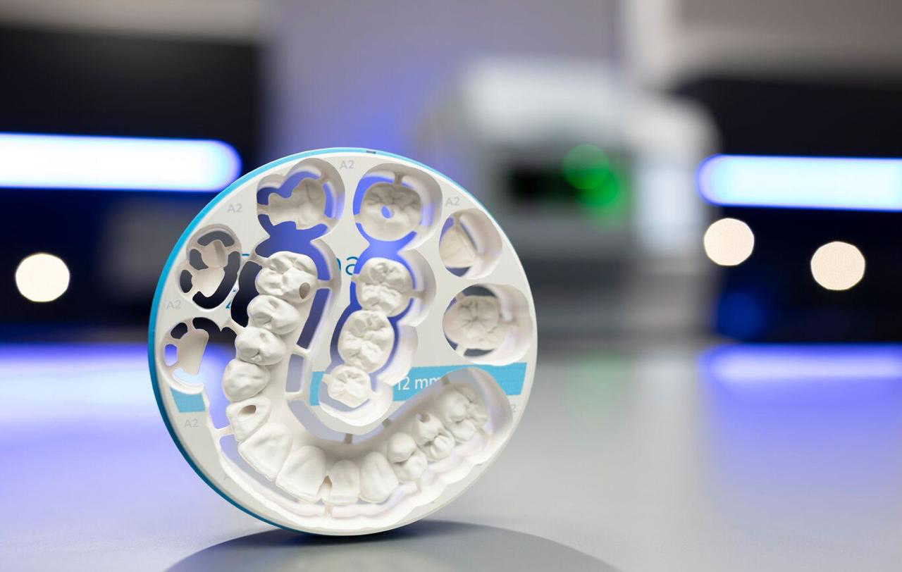 multilayer zirconia milling disc with milled crowns and an A2 shade gradient band in a dental CAD/CAM lab